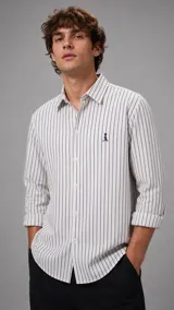 Camisa de manga larga con cuello italiano y diseño a rayas verticales azul marino sobre fondo blanco. Cuenta con cierre frontal de botones y un pequeño logo bordado en el pecho.