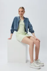 Vestido corto de punto a cuadrillé en tonos verde claro y blanco, de corte ajustado y sin mangas.