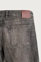 Jeans flare fit de denim de algodón en color gris con efecto lavado. Presentan diseño de cinco bolsillos, tiro medio y cierre frontal con cremallera y botón.