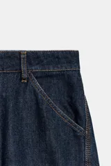 Jeans de mezclilla de tiro medio, diseño barrel con costuras en contraste de color ocre y bolsillos delanteros y traseros.