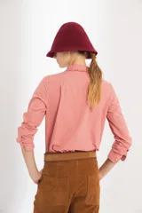 Pantalón de gamuza color marrón, de tiro medio y corte slouchy. Presenta bolsillos laterales y traseros, cierre metálico frontal y forro interno con stretch.