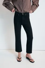 Jeans de tiro alto con cinco bolsillos, diseño cropped flare y bajo sin costuras. Cuenta con cierre frontal de cremallera y botón metálico.