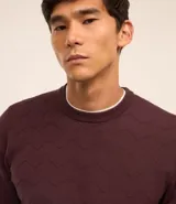 Suéter marrón de punto con textura en zigzag, cuello redondo y manga larga.