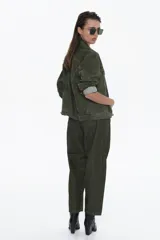 Chaqueta de denim color marrón, estilo trucker, con cuello camisero, bolsillos frontales con tapa y cierre de botones metálicos. Presenta un calce oversized.