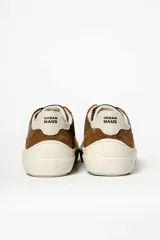 Zapatillas deportivas de cuero color crema, con detalles en gamuza color beige y verde.