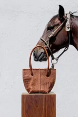 Cartera estructurada de cuero con textura crocco en color tostado, con manijas largas y detalles de terminación artesanal en los bordes. Cuenta con clip de cierre y un bolsillo interno.