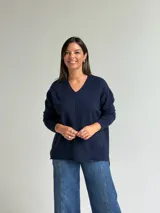 Sweater de punto en color azul marino, con escote en V, manga larga con puños acanalados y costura central vertical en el frente.