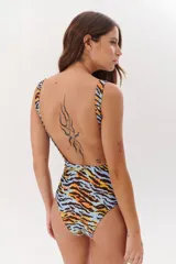 Malla enteriza negra con estampado de hojas de palmeras, flores y aves exóticas.