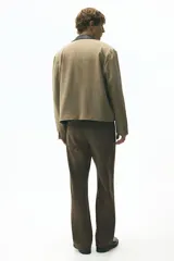 Jeans de cinco bolsillos en denim de algodón rígido, color marrón oscuro con efecto lavado. Modelo de cintura estándar con cierre y corte relajado, pierna recta y amplia desde el muslo.