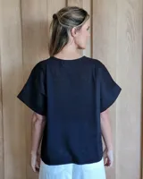 Remera blanca de corte holgado con cuello redondo y mangas cortas.