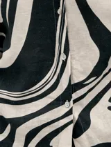 Conjunto de camisa y pantalón de lino color verde con estampado de flores blancas. La camisa es de manga larga y corte holgado.