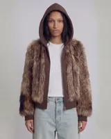 Campera con capucha de estilo híbrido, que combina una base de buzo con cierre frontal y paneles frontales y de mangas confeccionados en piel sintética de pelo largo en tonos marrones.