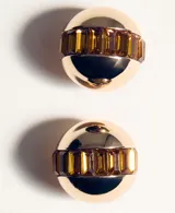 Aros tipo botón con diseño esférico en tono dorado, con una franja central decorada con cristales en tono ámbar.
