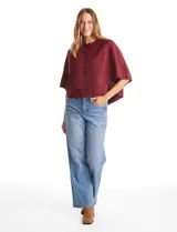 Capa de punto color bordó con diseño envolvente de doble capa superpuesta. Presenta cuello a la base, cierre frontal con botones y mangas estilo japonés con terminaciones acanaladas.