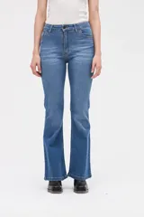 Jean de tiro medio con corte ajustado en cintura y caderas, y piernas ligeramente acampanadas. Presenta un lavado azul clásico con costuras reforzadas y cierre frontal con botón.