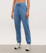Pantalón jogger deportivo de modal color azul, con cintura elástica ajustable con lazo, bolsillos delanteros aplicados, costuras frontales decorativas y puños elásticos en los tobillos.