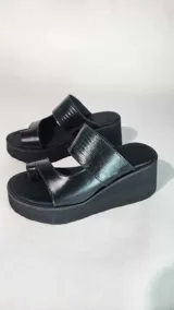 Sandalias de cuero negro con plataforma alta, diseño de doble tira con textura y presilla para el dedo.