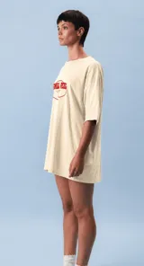 Remera oversize color lila con estampa frontal gráfica en tonos marrón y crema. Presenta cuello redondo, mangas cortas y un corte holgado.