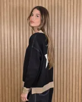 Cardigan de punto color marrón con detalles en tono arena en los bordes de la botonera, cuello en V, dobladillo y puños. Cuenta con cierre frontal de botones.