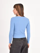 Remera de manga larga con diseño de rayas horizontales finas en blanco y negro, cuello redondo y corte ajustado.