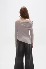 Sweater de punto acanalado color gris claro, con diseño de hombros descubiertos y cuello asimétrico drapeado. Presenta mangas largas y un corte ajustado al cuerpo.