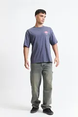 Remera de manga corta con calce oversize, confeccionada en algodón. Presenta un diseño estampado en la espalda con un gráfico abstracto y la palabra 'blurred'.