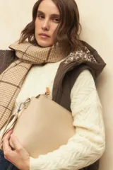 Bufanda a cuadrillé en tonos beige con flecos en los extremos.