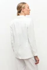 Blazer de lino color blanco, de corte clásico con solapas y cierre frontal de un botón.