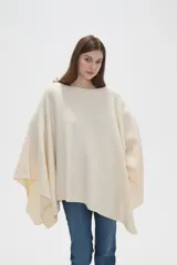 Poncho crudo de tejido de punto con diseño holgado y sin mangas.