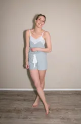 Pijama de algodón color gris claro, compuesto por una musculosa con escote en V y detalle de puntilla blanca elastizada, y un short con elástico y lazo blanco en la cintura.