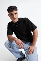 Remera de manga corta con calce boxy, corte recto y hombros caídos. Presenta escote redondo y diseño liso.