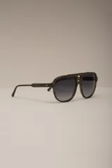 Lentes de sol estilo aviador con montura gruesa de acetato con patrón carey en tonos verde oliva y negro. Lentes oscuros con degradado gris.
