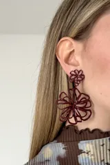 Aros colgantes color bordó, con diseño de doble flor elaborada en alambre metálico entrelazado.