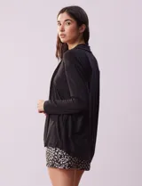 Set de pijama de tres piezas marca René Rofé, compuesto por un saco negro, una musculosa con estampado floral en blanco y negro y un short con estampado floral en blanco y negro.