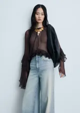 Jeans wide leg de tiro medio, confeccionados en tejido de algodón estilo vaquero, con diseño de cinco bolsillos, cierre de cremallera y botón, y bajo deshilachado.