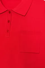 Jersey polo de punto liso color rojo, con cuello solapa, manga larga y bolsillo de plastrón en el delantero. Cierre frontal con botones.