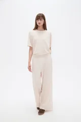 Pantalón ancho de tiro alto, color natural, confeccionado en poliéster con detalles de strass.