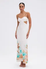 Vestido largo blanco de viscosa con estampado tropical en la parte inferior, tirantes con detalles de cuentas de madera, aberturas laterales en la cintura y cierre de cremallera invisible.