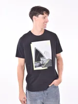 Remera negra de corte regular con estampa fotográfica del edificio de la Ópera de Sídney y un skater haciendo parkour.