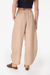 Pantalón de lino italiano color terracota, de corte relajado y fluido con cintura elástica fruncida.
