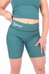 Calza biker deportiva color verde con tiro alto y logo estampado en la cintura.