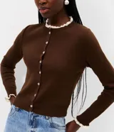 Cardigan de punto marrón de manga larga, con cierre frontal de botones y detalles de encaje blanco en el cuello redondo y los puños.