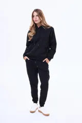 Buzo tipo canguro de felpa color marrón, con capucha ajustable mediante cordones y bolsillo frontal tipo canguro.