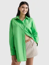 Camisa verde de popelín de algodón orgánico, corte oversize con hombros caídos, cuello inglés, bolsillo de parche en el pecho y logo bordado en la manga.