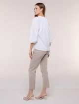 Blusa de gasa de color lila con calce holgado, cuello a la base con escote en V y cartera de botones a tono. Cuenta con fruncidos en el cuello y hombros que otorgan volumen, manga tres cuartos estilo abullonado con puño elastizado y ruedo suavemente redondeado.