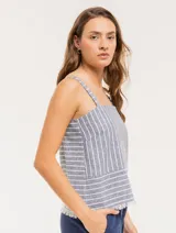 Musculosa de lino a rayas verticales azules y blancas, con breteles anchos y ruedo con flecos.