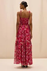 Vestido largo color fucsia con estampado floral, escote cuadrado y tirantes anchos adornados con detalles texturizados. Presenta un corpiño estructurado y una falda larga fluida con capas y vuelo.
