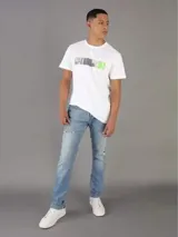 Remera blanca de algodón con cuello redondo y mangas cortas. Presenta un estampado gráfico frontal compuesto por bloques de color gris, negro y verde lima.