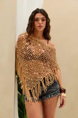 Top corto tejido en crochet de color beige con diseño de red, adornado con lentejuelas circulares y flecos en el borde inferior.