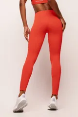 Calza deportiva larga de tiro alto en color rojo, confeccionada en poliamida de alta performance con cintura ancha de sustentación firme y diseño sin costura frontal.